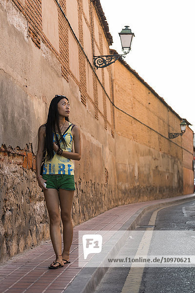 'A young Chinese woman walking around downtown Alcala de Henares  a historical and charming city near to Madrid; Alcala de Henares  Spain'