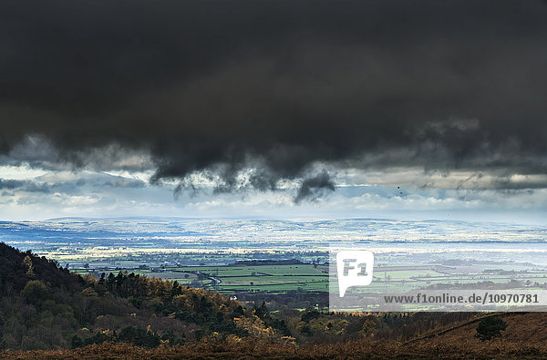 Dunkle Gewitterwolken über einer Landschaft mit grünem Ackerland; Yorkshire  England'.