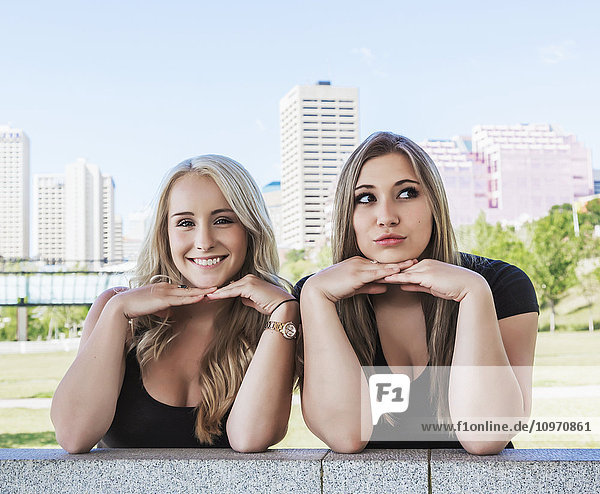 Zwei Freundinnen posieren für die Kamera  während sie die freie Natur in einem Stadtpark in der Innenstadt genießen; Edmonton  Alberta  Kanada'.
