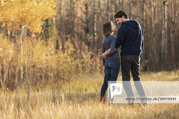 Ein junges Paar geht spazieren und genießt die Gesellschaft des anderen in einem Park im Herbst; Edmonton  Alberta  Kanada'.