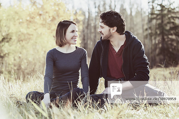 Ein junges Paar  das sich in die Augen schaut  während es eine romantische Zeit miteinander in einem Stadtpark im Herbst genießt; Edmonton  Alberta  Kanada
