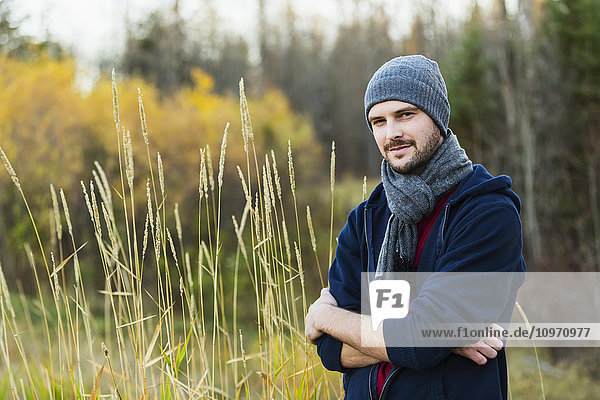 Porträt eines gut aussehenden jungen Erwachsenen  der einen Herbstausflug im Park genießt; Edmonton  Alberta  Kanada'.