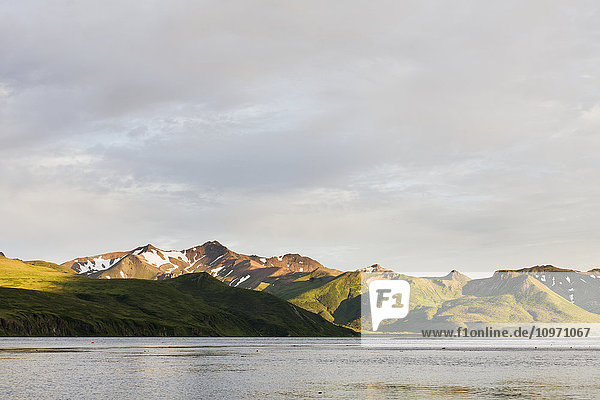 'Mountains And A Town Along The Coastline On Unimak Island; False Pass  Alaska  United States Of America'