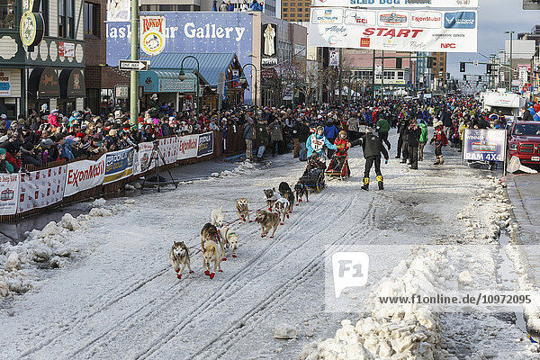 Kristy Berington runs down 4th avenue during the cermonial start day of Iditarod 2015.