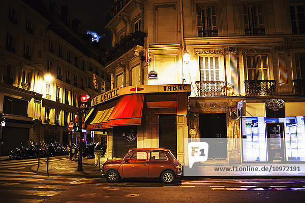 Stadtstraße mit einem roten Auto mit Heckklappe; Paris  Frankreich'.
