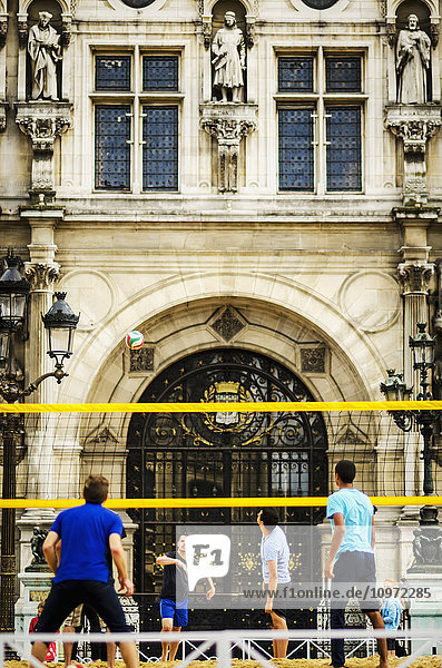Spieler bereiten sich darauf vor  den Ball bei einem Volleyballspiel vor einem historischen Gebäude zu schlagen; Paris  Frankreich
