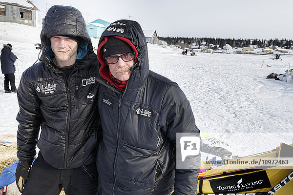 Father and son Mitch and Dallas Seavey pose for a photo in the afternoon at the White Mountain checkpoint during Iditarod 2015