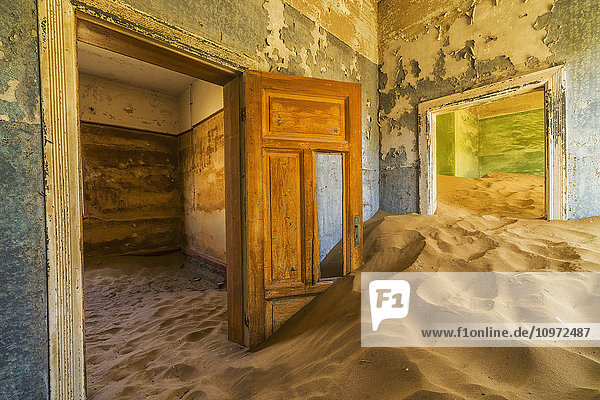 Sand in den Räumen eines bunten und verlassenen Hauses; Kolmanskop  Namibia