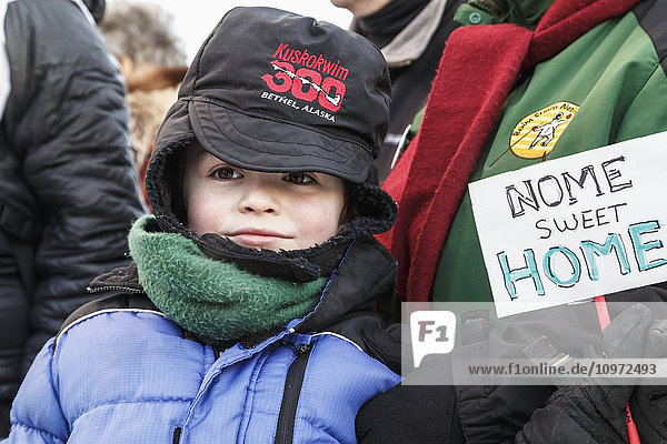 Aaron Burmeisters 6-jähriger Sohn hält während des Iditarod 2015 ein Schild mit der Aufschrift Nome Sweet Home .