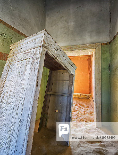 Sand in den Räumen eines bunten und verlassenen Hauses; Kolmanskop  Namibia