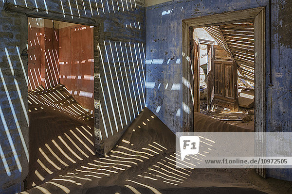 Sand in den Räumen eines bunten und verlassenen Hauses; Kolmanskop  Namibia