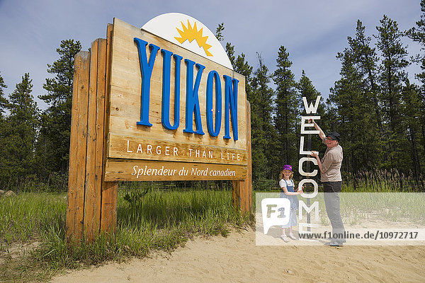 Mutter und Tochter stehen neben einem Welcome and Yukon -Schild  Yukon Territory  Kanada  Sommer