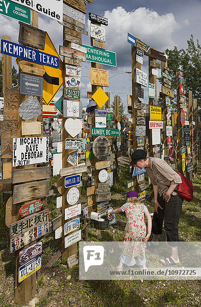 Mother and daughter explore the Signpost Forest  Watson Lake  Yukon Territory  Canada  summer