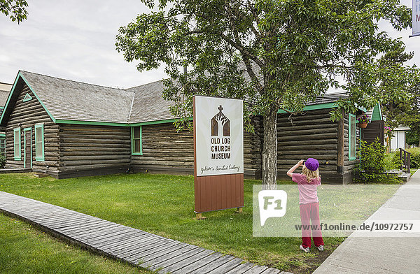 Young girl explores the Old Log Church Museum  Whitehorse  Yukon Territory  Canada  summer