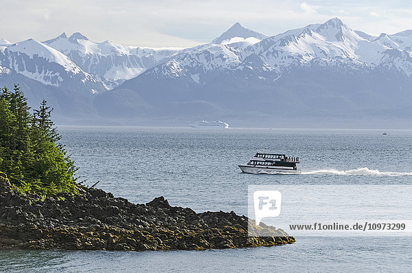 Scenic view of Lynn Canal and the Chilkat Mountains with a tour boat in the foreground  Southeast Alaska