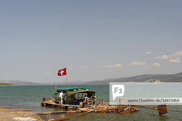 Menschen auf einem handgefertigten Floß  das am Ufer des Lake Leberge  Yukon Territory  Kanada  vertäut ist