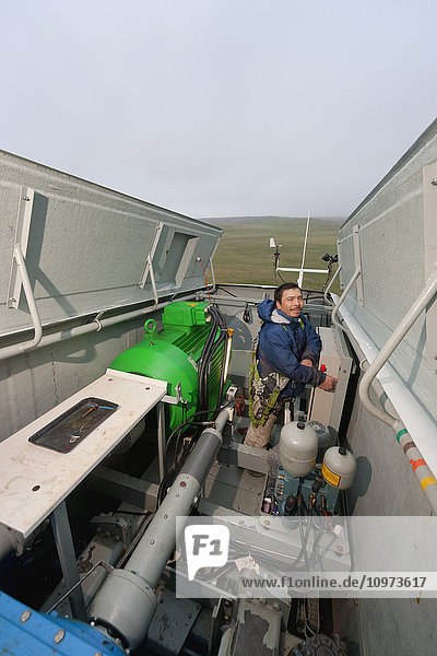 Ein Techniker aus Alaska prüft die Flügel einer Windkraftanlage auf Schäden  St. Paul Island  Südwest-Alaska  USA  Sommer'.