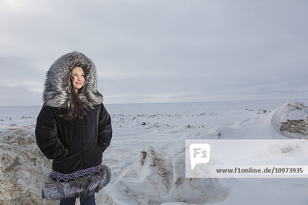 Weiblicher Jugendlicher in traditionellem Pelzparka auf dem Eis des Arktischen Ozeans  Barrow  North Slope  Arctic Alaska  USA  Winter'.