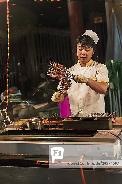 'A Muslim Man Preparing Some Mutton In His Traditional Barbecue; Xian Shaanxi Province China'