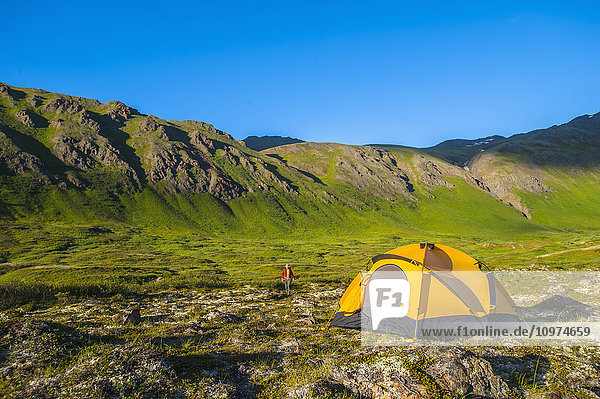 A man at his campsite at Hanging Valley in South Fork near Eagle River on a summer day in South Central Alaska.