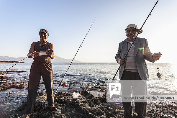 Männer beim Fischen in der Abenddämmerung am Ufer des Mittelmeers  in der Ferne der Berg Casius; Cevlik  Türkei'.