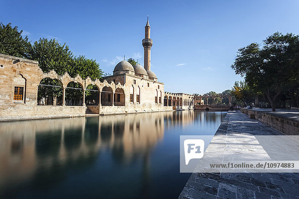 'Chamber of Abraham  wall and minaret reflected in the tranquil water of a lake; Sanliurfa  Turkey'
