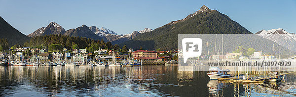 'Downtown Sitka on a clear summer evening; Sitka harbor and docked fishing boats in the foreground with the Sisters Mountains in the background  Southeast Alaska  USA  Summer'
