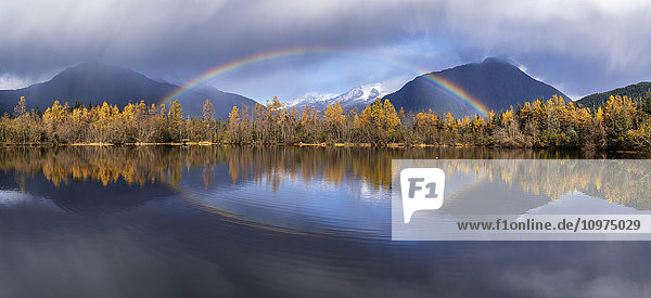 Landschaftlicher Blick auf herbstliche Regenschauer und einen Regenbogen  der sich im Moose Lake spiegelt  Mendenhall Recreation Area  Tongass National Forest  Juneau  Südost-Alaska