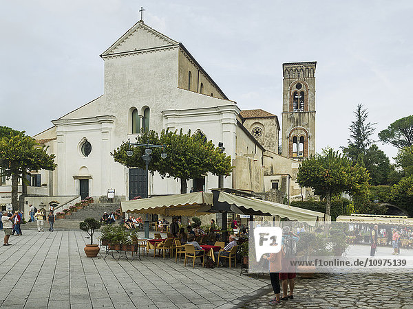 Kirchengebäude mit Fußgängern und einem Sitzbereich im Freien; Ravello  Italien