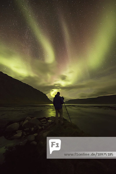 Mann fotografiert das Nordlicht; Island'.