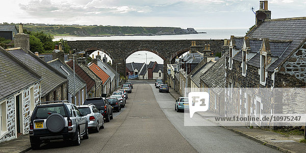 Eine von Häusern gesäumte Straße  die zum Meer hinunterführt; Cullen  Schottland'.
