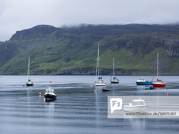 'Boats moored in the tranquil water of a harbour  Skye Island; Portree  Scotland'