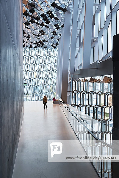 Mutter und Tochter erkunden das Innere der öffentlichen Konzerthalle Harpa  die von dem dänischen Büro Henning Larsen Architects und dem isländischen Büro Batteriao Architects entworfen wurde; die Glasfassade wurde von dem isländischen Glaskünstler Olafur Eliasson entworfen; Reykjavik  Island .