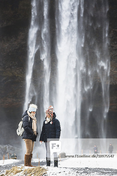 Touristen besuchen den Wasserfall Seljalandsfoss; Island'.