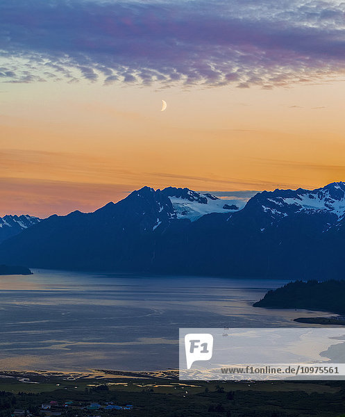 Der Mond hängt im Sonnenuntergang über Port Valdez und den Chugach Mountains südlich von Valdez; Alaska  Vereinigte Staaten von Amerika'.