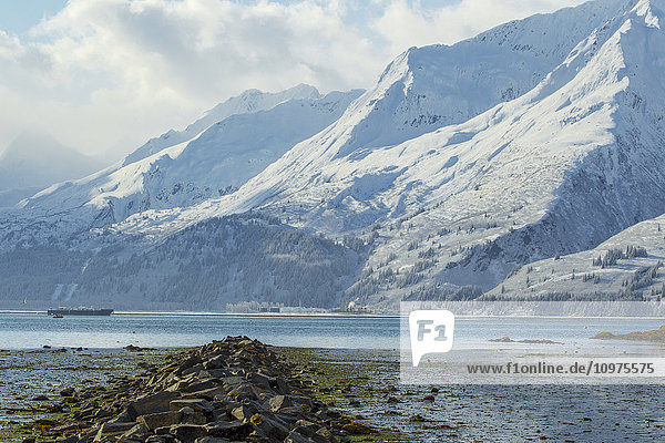 A rock wall leads out to Port Valdez during low tide  Southcentral Alaska  winter