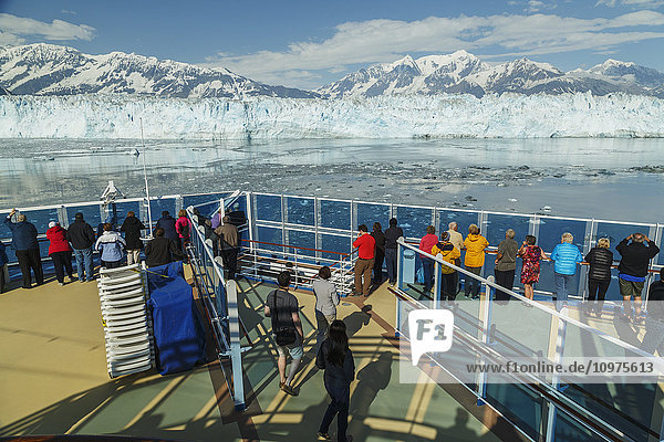 Tourists aboard the Coral Princess cruise ship view Hubbard Glacier and the St. Elias Mountains in Disenchantment Bay  Southeast Alaska  Summer