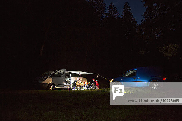 Paare  die nachts gemeinsam vor ihren Wohnmobilen campen; Bled  Slowenien