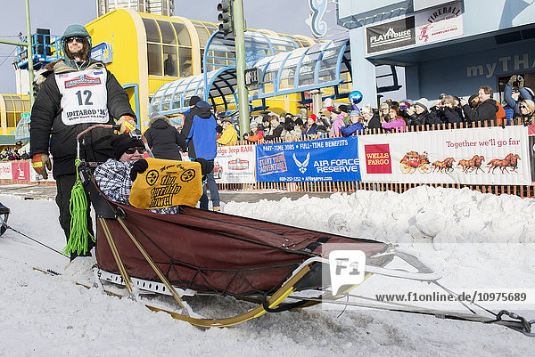 Nicolas Petit and team leave the ceremonial start line with an Iditarider during the 2016 Iditarod