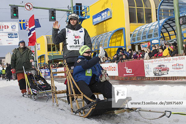 Joar Leifseth Ulsom und sein Team verlassen die feierliche Startlinie mit einem Iditarider während des Iditarod 2016