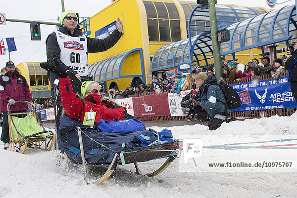 Ryan Redington and team leave the ceremonial start line with an Iditarider during the 2016 Iditarod