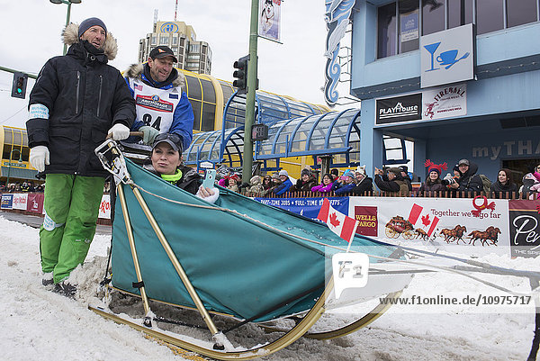 Hans Gatt and team leave the ceremonial start line with an Iditarider during the 2016 Iditarod