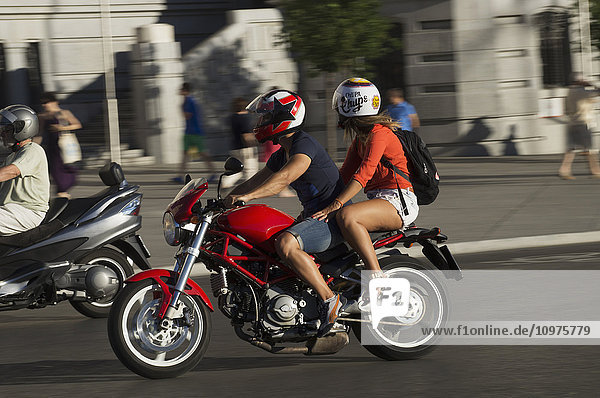Fußgänger und Motorradfahrer auf der Straße an der Plaza de Cibeles; Madrid  Spanien