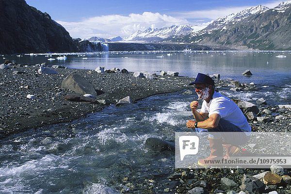 Man Shaves Near Stream Margerie Glacier Se Alaska Scenic