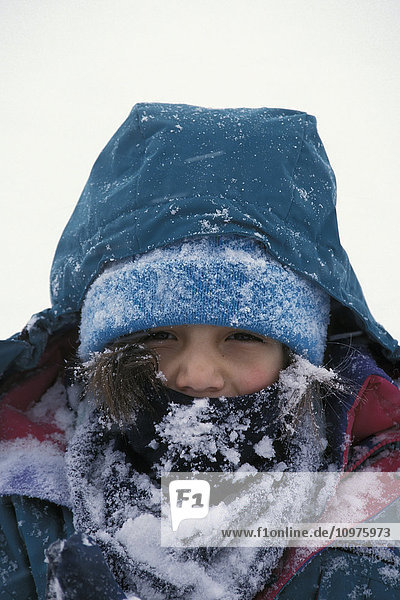 Portrait Of Child Bundled Up For Winter Covered In Snow  Alaska Winter.