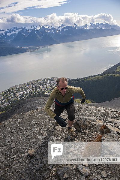 Man tops out on the summit ridge of Mount Marathon trail  above Seward  Southcentral Alaska  Summer