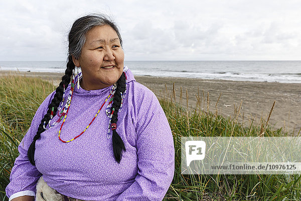 Porträt einer Yupik-Eskimo-Frau in Kuspuk im Freien sitzend Nome  Alaska Sommer