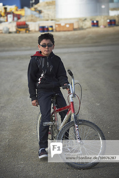 'Young boy on a bike; Cambridge Bay  Nunavut  Canada'
