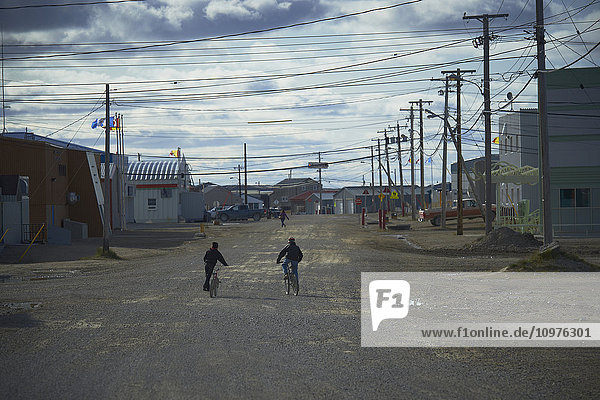 'Boys on bikes on a street; Cambridge Bay  Nunavut  Canada'