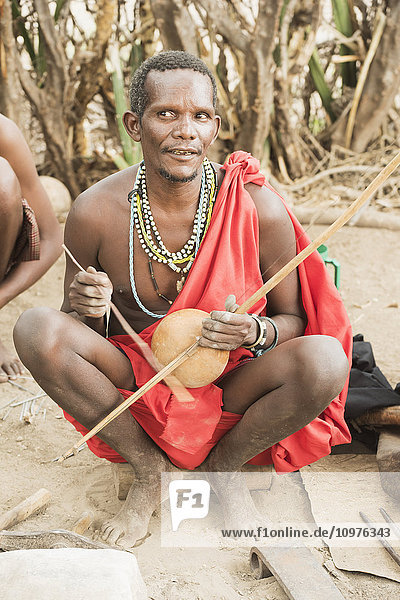 Datoga-Ältester spielt traditionelles Saiteninstrument in der Nähe des Eyasi-Sees; Tansania'.